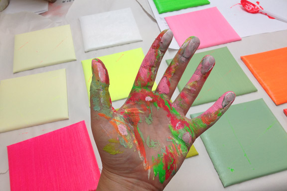 Skønt med maling på fingrene - og 15x15 lærreder i alle regnbuens farver. Fotograf: Susanne Randers