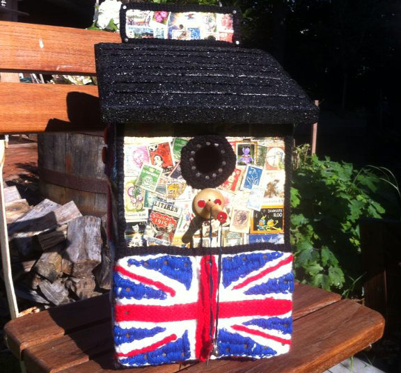 Yarnbombing fuglehus med Union Jack og frimærker, kreeret og fotograferet af Louise