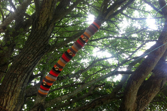 Retrofarvet yarnbombing af gren på et stort gammelt træ. Kreeret og fotograferet af Louise